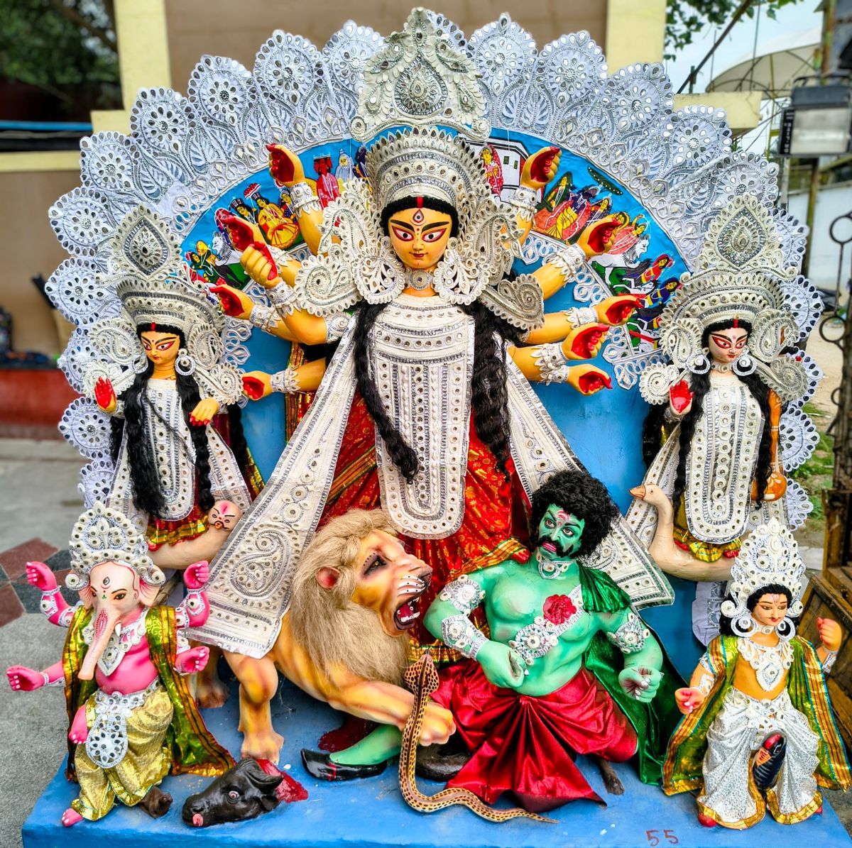 Clay pratima of Maa Durga slaying Mahishasura, with Lakshmi, Saraswati, Ganesh and Kartik before a silver daker saaj